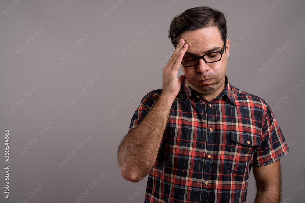 Handsome Persian man wearing eyeglasses against gray background Handsome Persian man wearing eyeglasses against gray background