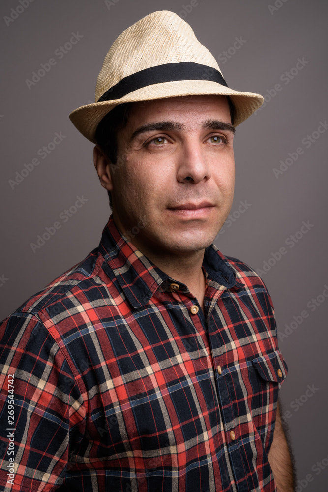 Handsome Persian tourist man ready for vacation against gray bac Handsome Persian tourist man ready for vacation against gray bac