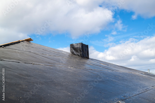 close up view of standard waterproofing layer of black color applied to protect roof and chimney from water penetration