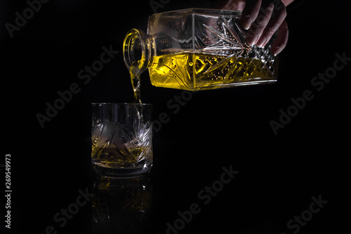 glass of whiskey and ice on black background