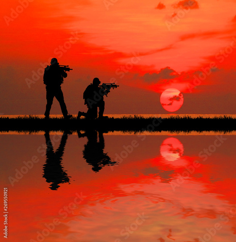 Silhouette of soldier with rifle on a sunset