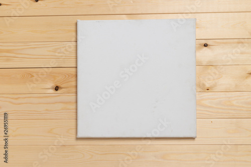 Empty white canvas frame on wooden table