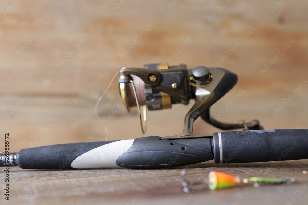 spinning with reel and lure on wooden background spinning with reel and lure on wooden background