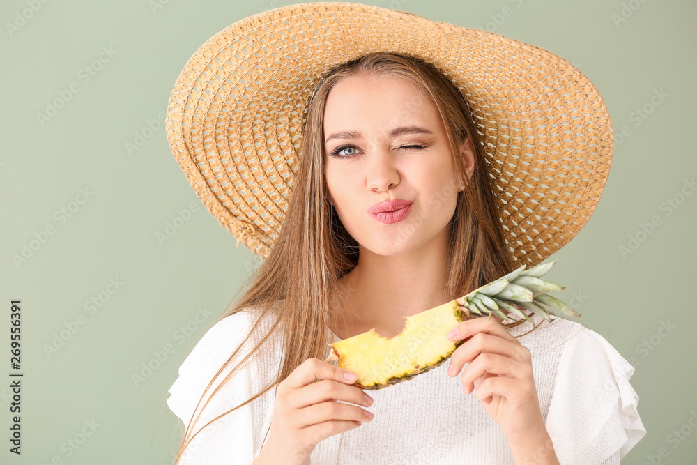 Beautiful young woman eating pineapple on color background Beautiful young woman eating pineapple on color background