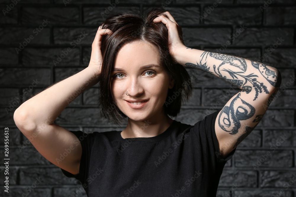 Beautiful tattooed woman on dark background Beautiful tattooed woman on dark background