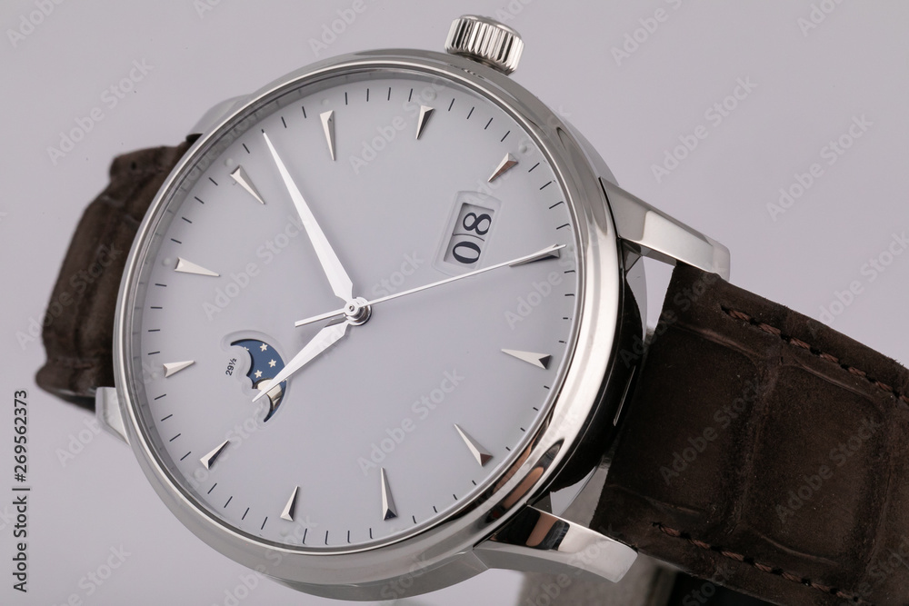 Mens silver watch with a white dial, golden clockwise, chronograph, with a black leather strap, isolated on white background. Mens silver watch with a white dial, golden clockwise, chronograph, with a black leather strap, isolated on white background.