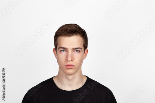 Portrait of a young handsome man in black t-shirt over white background.