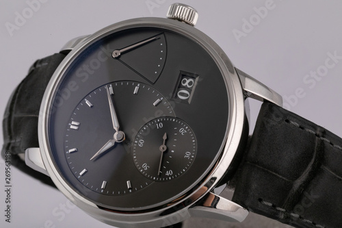 Mens silver watch with a black dial, black clockwise chronograph stopwatch with a black leather strap isolated on white background