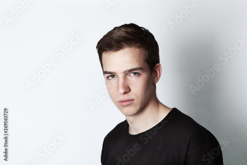 Portrait of a young handsome man in black t-shirt over white background.