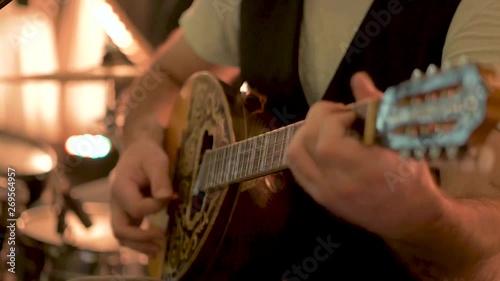 Detail man hand playing greek guitar bouzouki