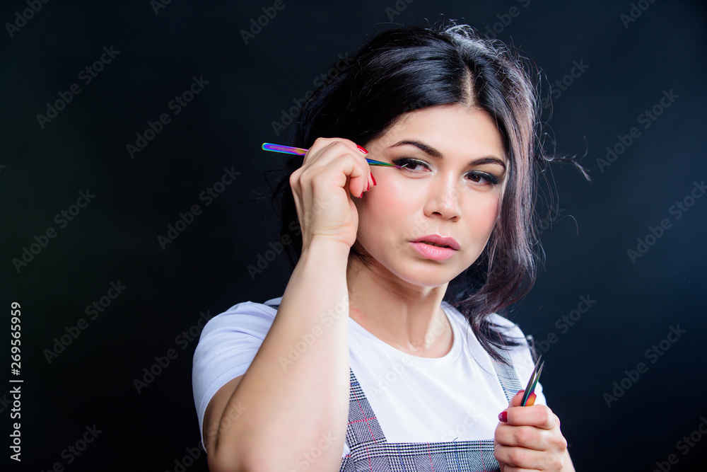 Obraz premium Girl makeup face hold tweezer for eyelash extension. Beauty shop concept. Professional eyelash extension tweezer. Makeup artist. Cosmetic tweezer. Extensions make everyday eye makeup unnecessary