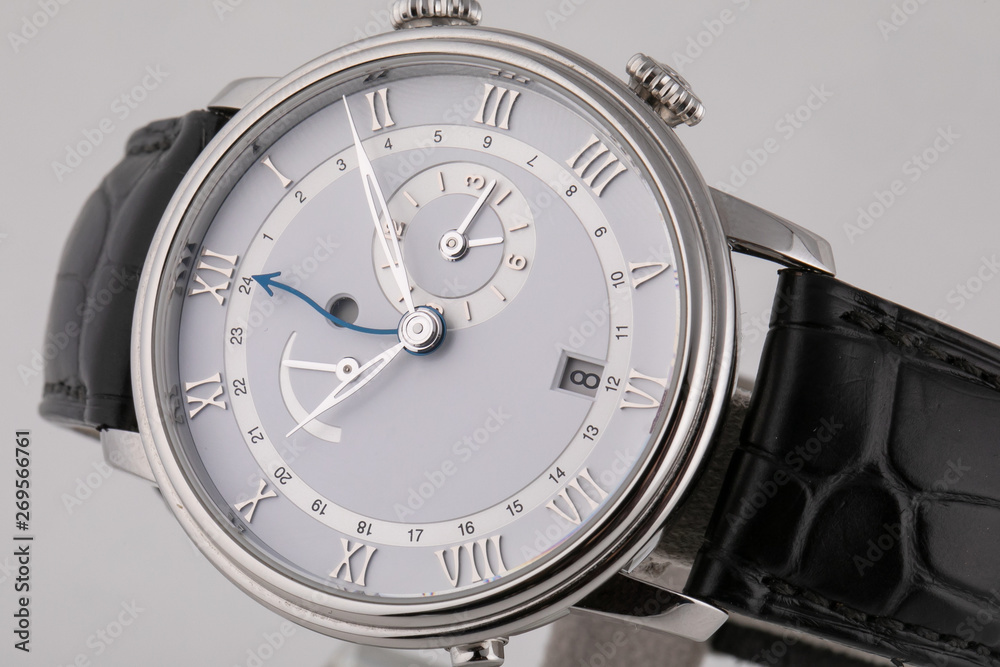 Silver wristwatch with white dial, silver clockwise, stopwatch and chronograph on black leather strap on white background Silver wristwatch with white dial, silver clockwise, stopwatch and chronograph on black leather strap on white background
