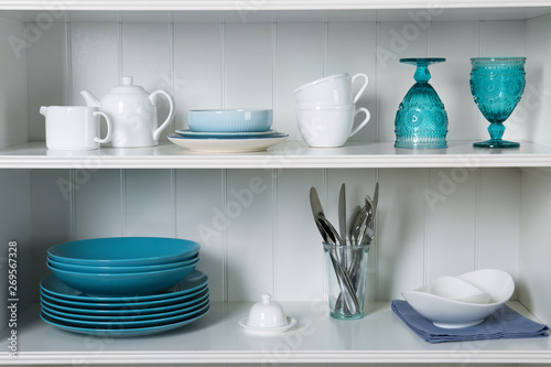 White shelving unit with set of dishware