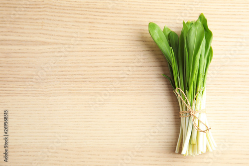 Bunch of wild garlic or ramson on wooden table  top view with space for text