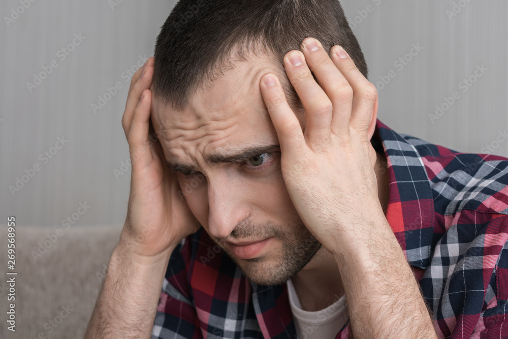 Fototapeta premium The man depression, he squeezes his head, close up