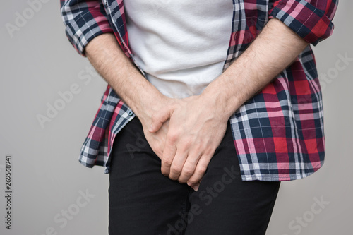 Man feeling a pain in his groin, wanting to the toilet, copy space, for advertising, slogan