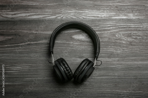 Stylish headphones on wooden background, top view