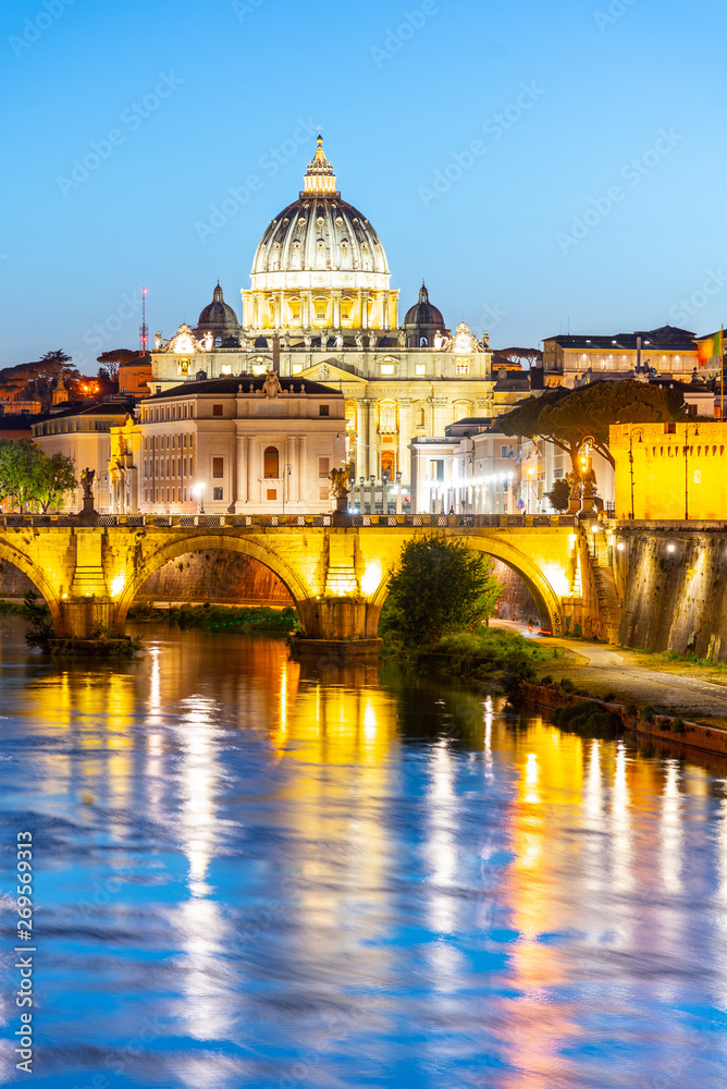 St Peters Basilica in Vatican and Ponte Sant'Angelo Bridge over Tiber River at dusk. Romantic evening cityscape of Rome, Italy
