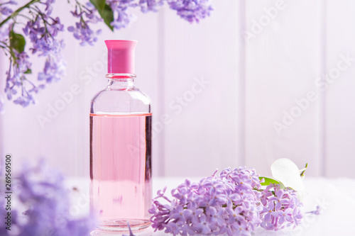 perfume bottle with lilac flowers on white background