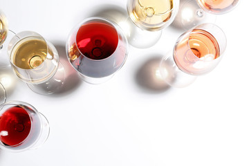 Different glasses with wine on white background, top view