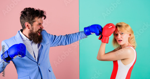 Couple in love competing in boxing. Female and male boxers fighting in gloves. Domination concept. Gender battle. Gender equal rights. Gender equality. Man formal suit and athletic woman boxing fight © be free