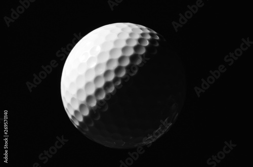 New white golf ball against dark background