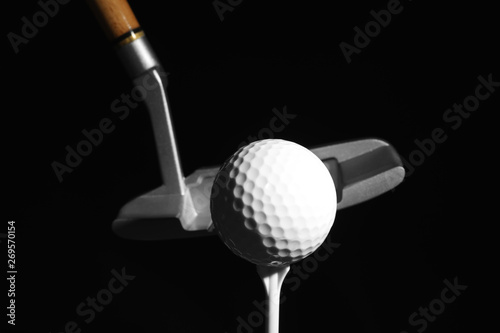 Golf club and ball against dark background