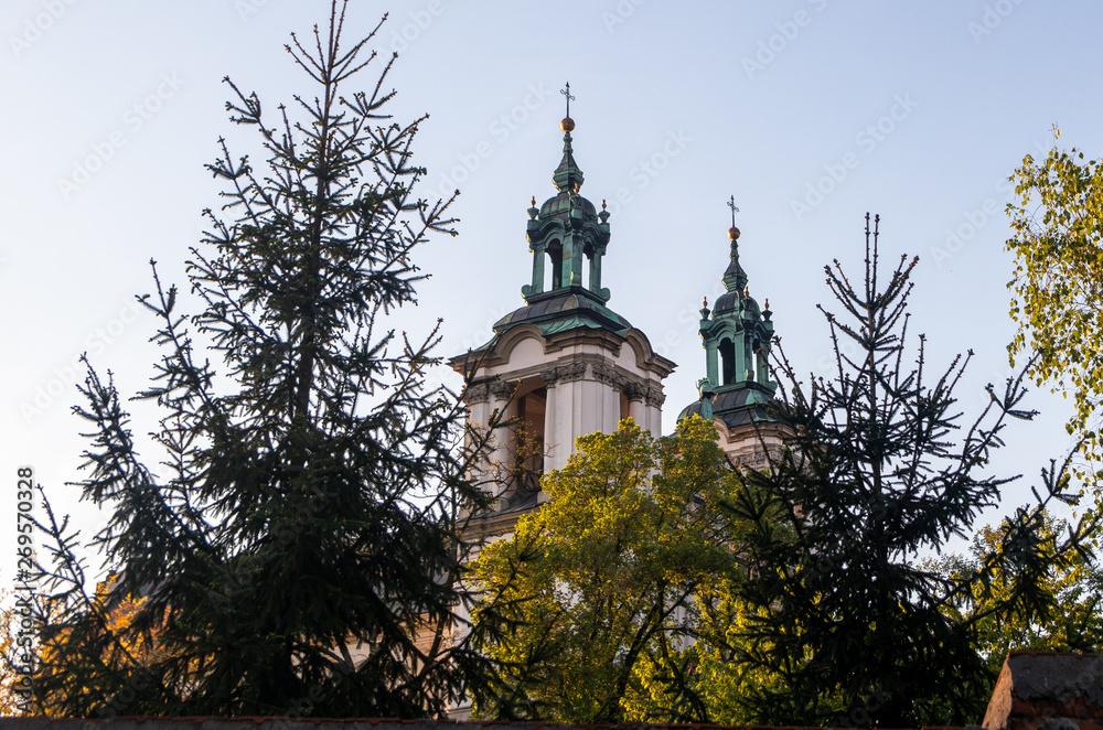 Roof of church in Krakow and top of evergreen trees Roof of church in Krakow and top of evergreen trees