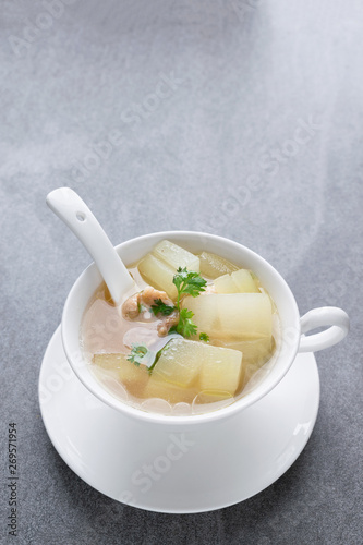 Boiled winter melon soup with chicken rib in white bowl on table.