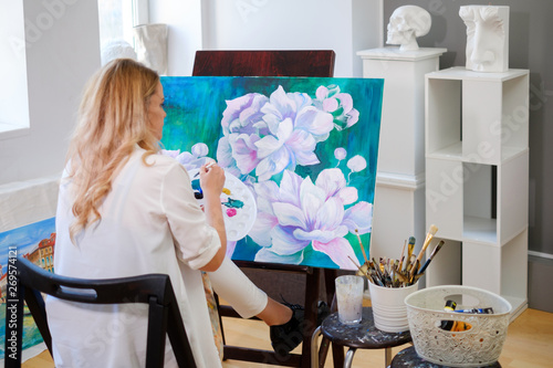 Creative painter paints a colorful picture in her studio photo