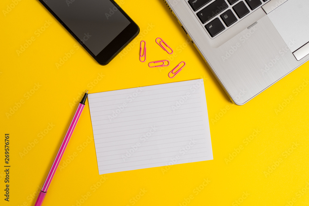 Trendy open laptop smartphone marker paper sheet clips colored background
