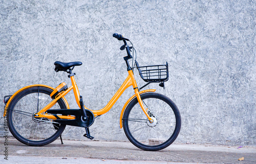 Yellow bicycle, black wheels parked on the wall.Vehicles with 2 wheels, driving with manpower.