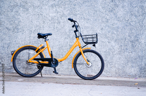 Yellow bicycle, black wheels parked on the wall.Vehicles with 2 wheels, driving with manpower.
