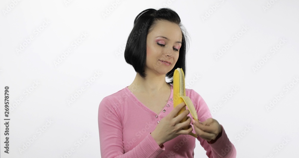 Young beautiful woman peeling a big banana Young beautiful woman peeling a big banana