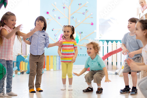 Group of happy children jumping indoor. Kids play together