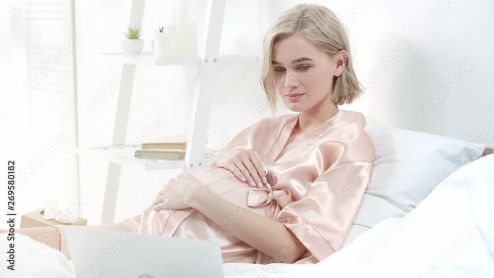 upset blonde pregnant woman crying while watching movie on laptop in bedroom upset blonde pregnant woman crying while watching movie on laptop in bedroom