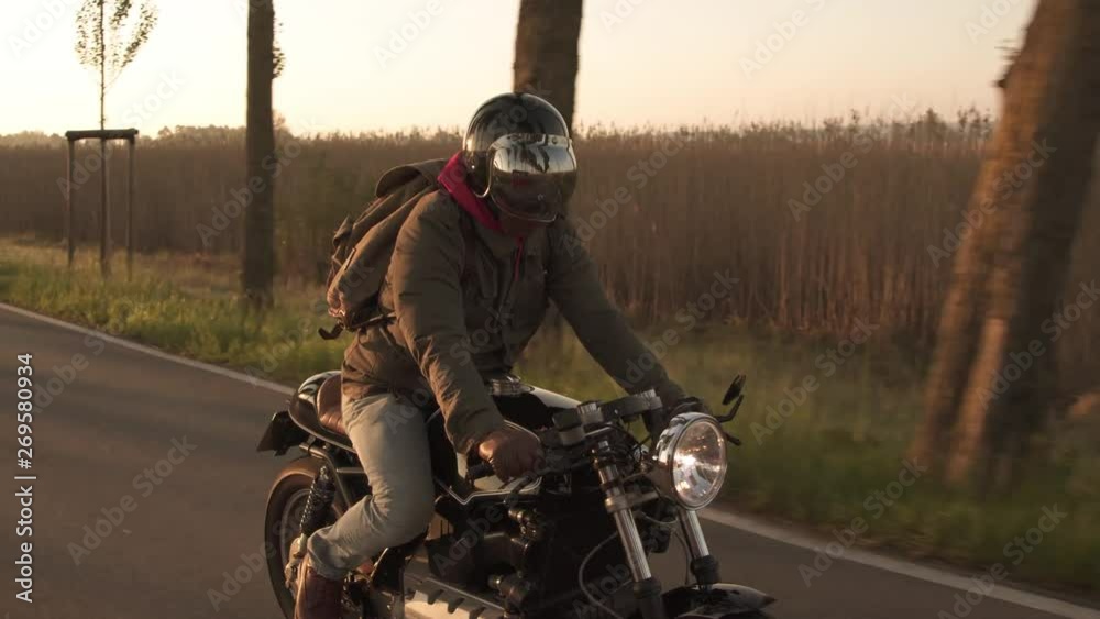 Motorycyclist riding his custom oldtimer bike through alley