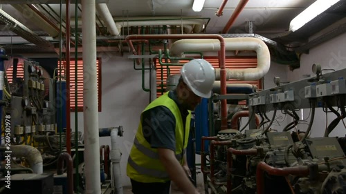 Caucasian Engineer with beard checking Cooling system, For the safety of the system. Low light room.