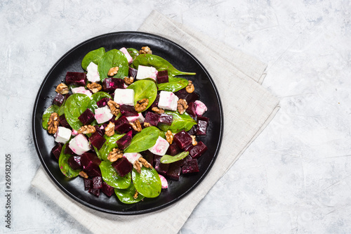 Fresh salad from spinach, beet and feta cheese with walnut.