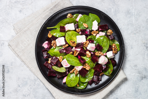 Fresh salad from spinach, beet and feta cheese with walnut.