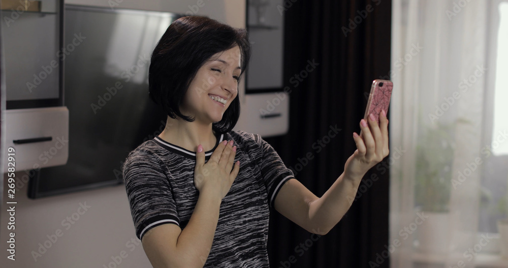 Woman having video chat using smartphone enjoying chatting to friend Woman having video chat using smartphone enjoying chatting to friend