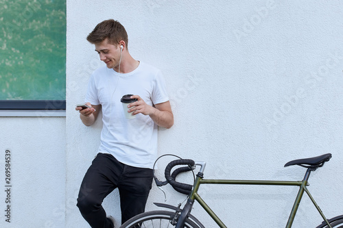 Handsome hipster man posing with bicycle in the city.