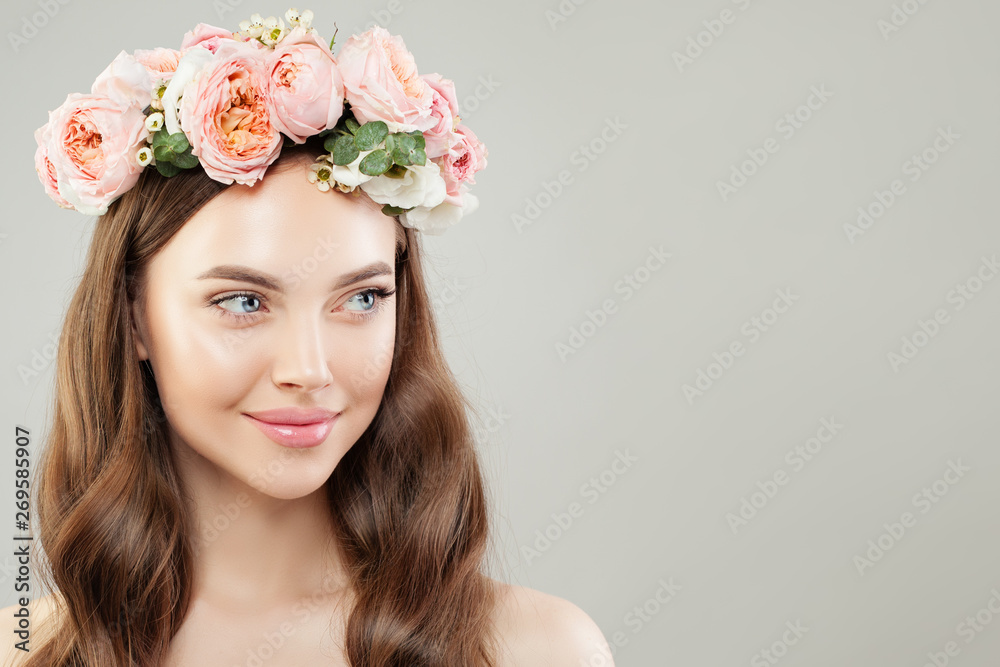 Portrait of beautiful woman with clear skin and flowers on white. Natural beauty