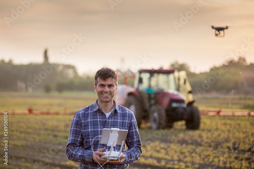 Farmer driving drone above field photo