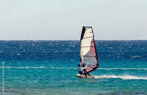 young surfer girl rides a sail in the Red Sea in Egypt Dahab