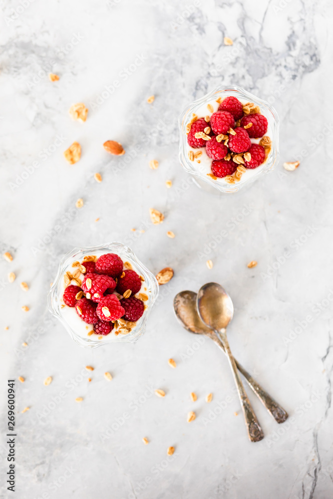 Fresh Raspberries on Top of Granola and Yogurt Parfait On Light Background Top View