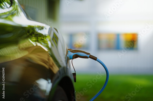 Electric Car is charging in front of house
