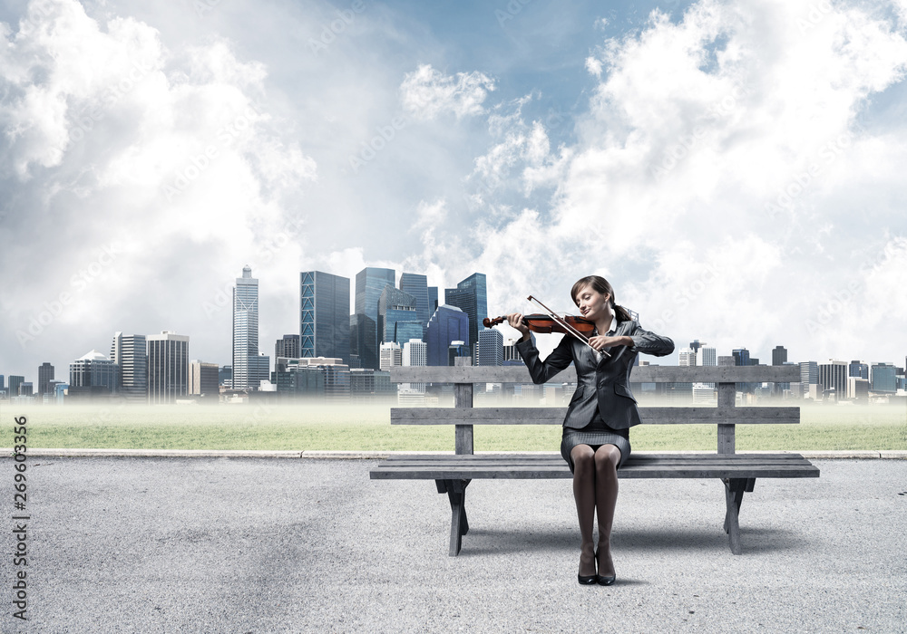 Young woman with violin sitting on wooden bench Young woman with violin sitting on wooden bench