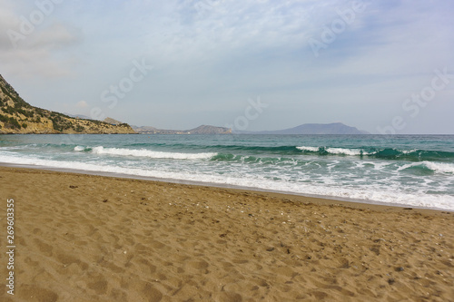 A calm sea is beautiful emerald color and the sandy beach. Crimea in the offseason