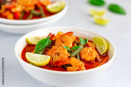 Thai Shrimp Red Curry in the Bowls with Chopsticks Served with Basil and Lemon on White Background. Thai Food, .Oriental Food, Asian Food, Thai Cuisine Concept.
